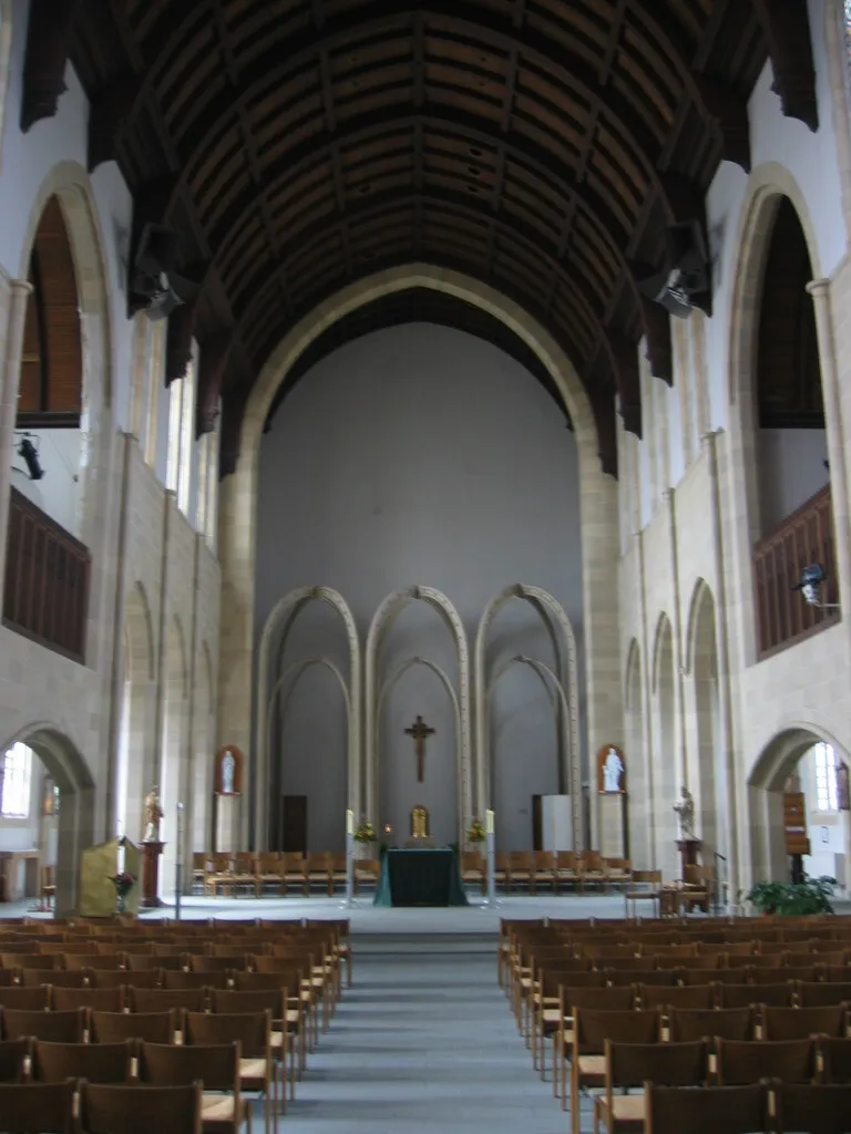 The chapel in 1989, with the sanctuary wall bare where the mural had been, a plain crucifix and tabernacle, and loose chairs in place of pews.