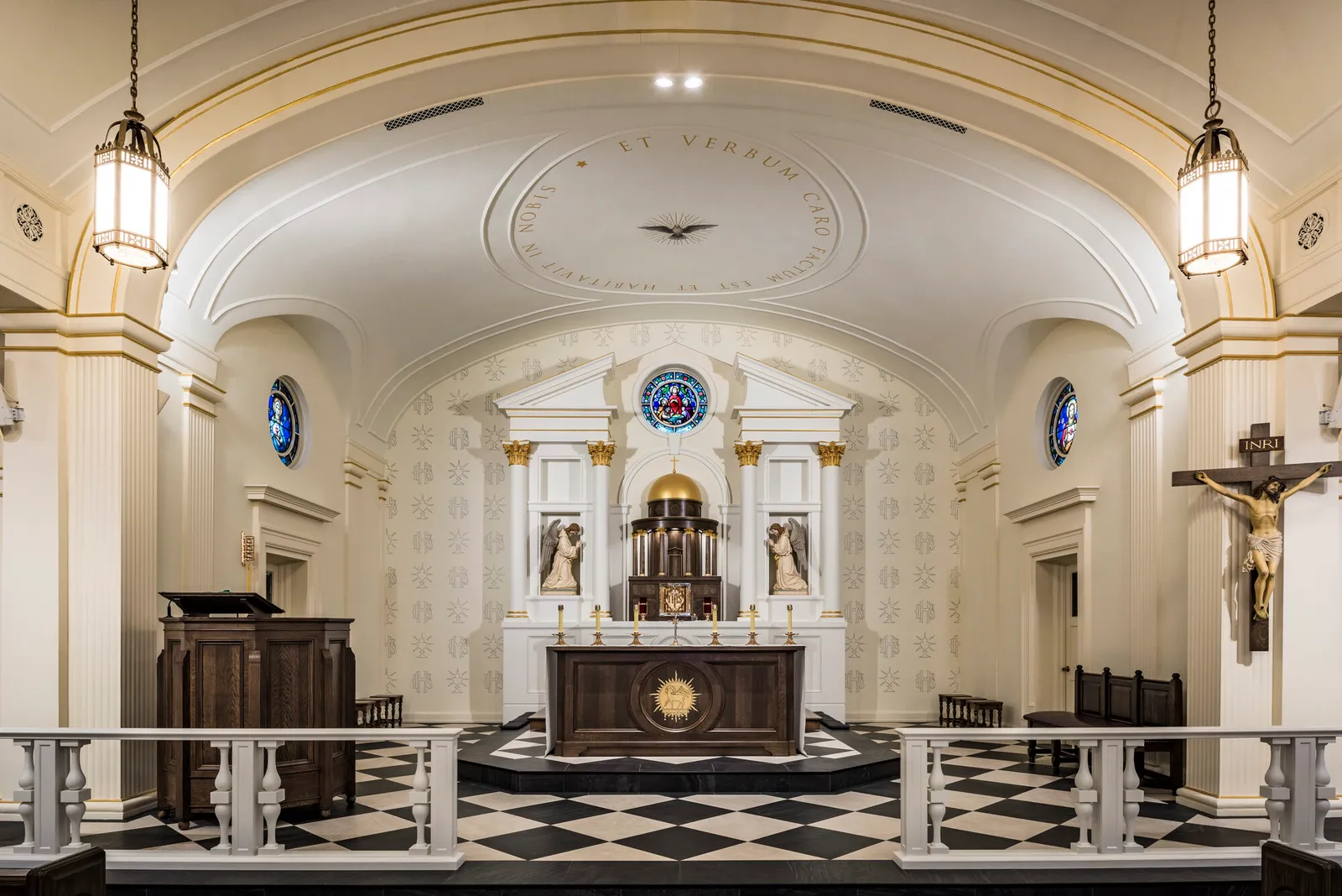 Close view of the sanctuary with a gold-domed tabernacle canopy, kneeling angel statues, and a stained-glass rose window above.