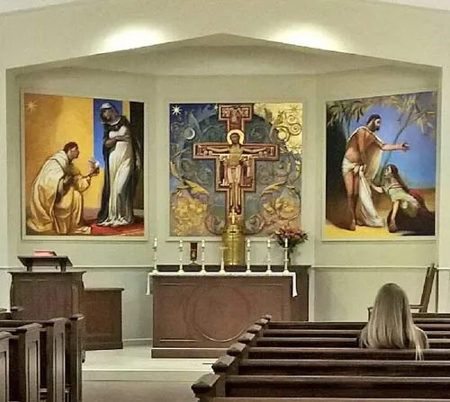 Chapel sanctuary with three large murals and a Franciscan crucifix above the altar