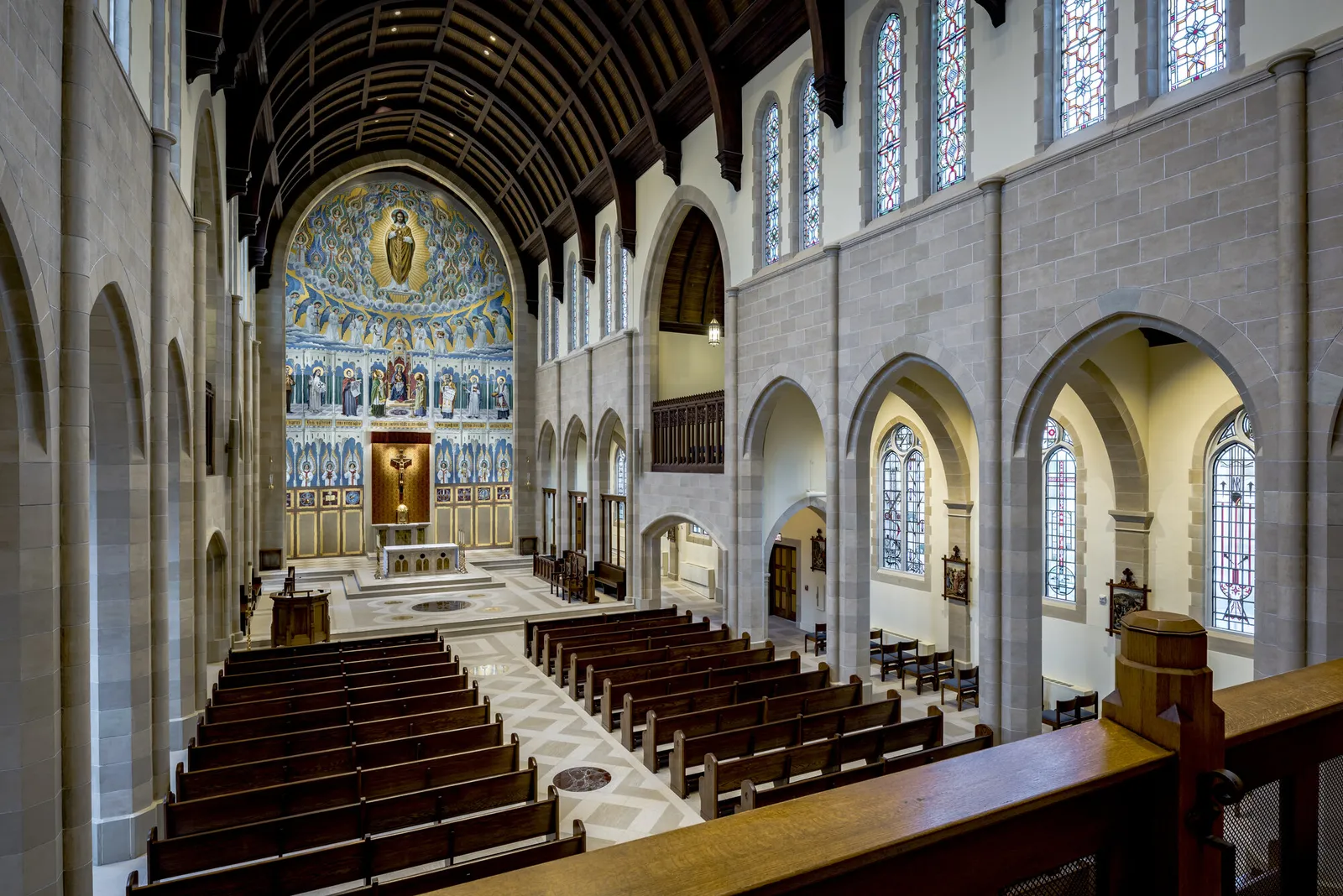 The nave from the gallery: the oak pews and the patterned floor leading to the restored sanctuary.