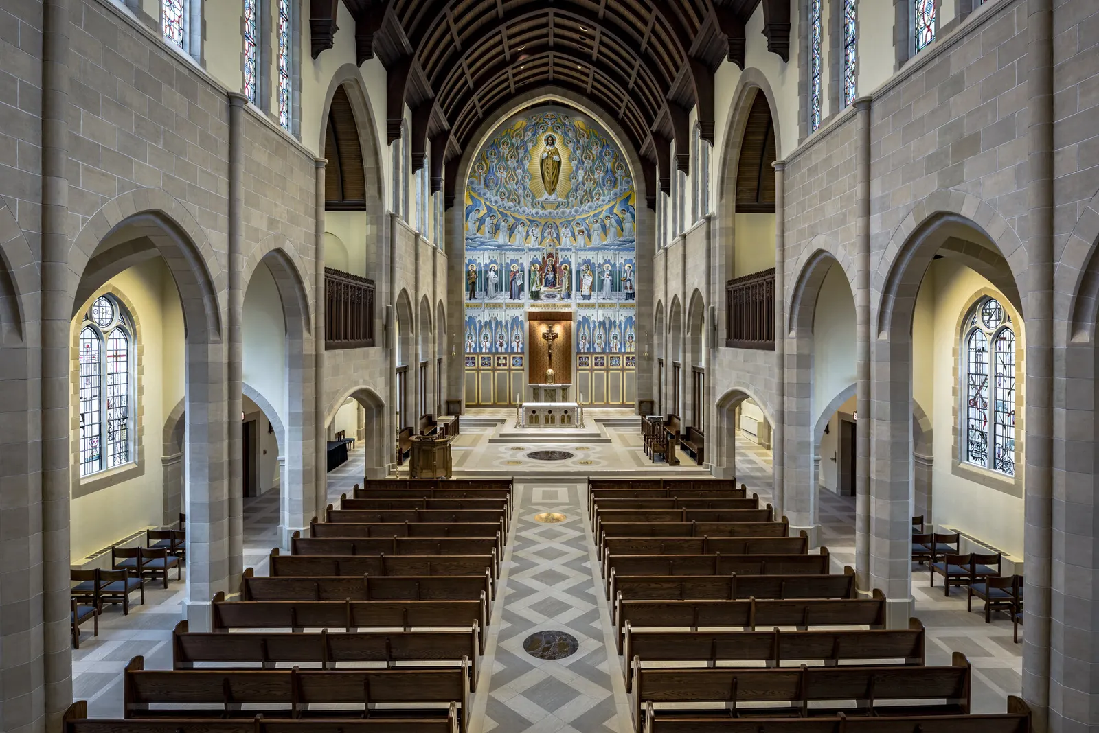 The nave from the west door: the stone arcades and clerestory, the timber roof and the painted sanctuary beyond.