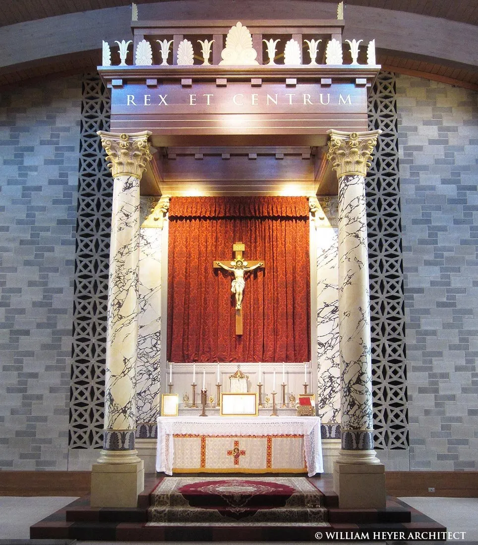 Altar baldachin on marble columns inscribed Rex et Centrum, with crucifix against a red curtain