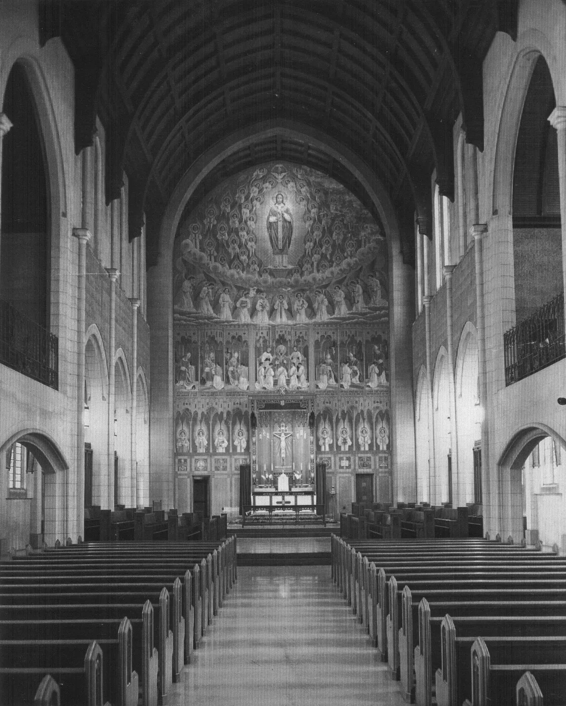 Black-and-white historic photograph of the chapel nave, with the original Gerhard Lamers sanctuary mural of Christ among angels and saints above the high altar.