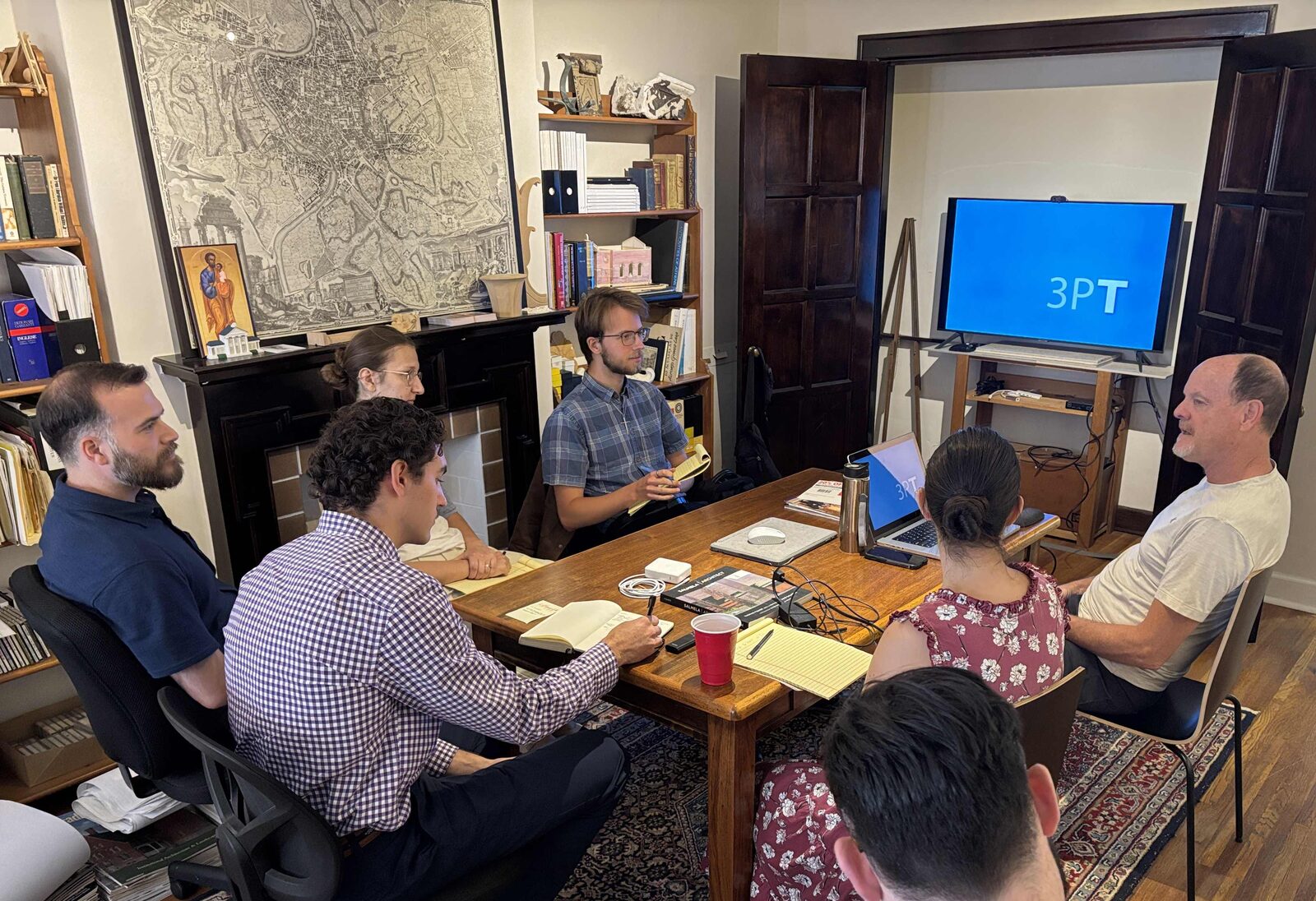 The William Heyer Architect studio gathered around the conference table for a presentation